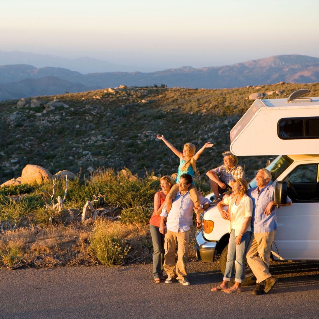 Family standing outside of an RV while on a road trip.