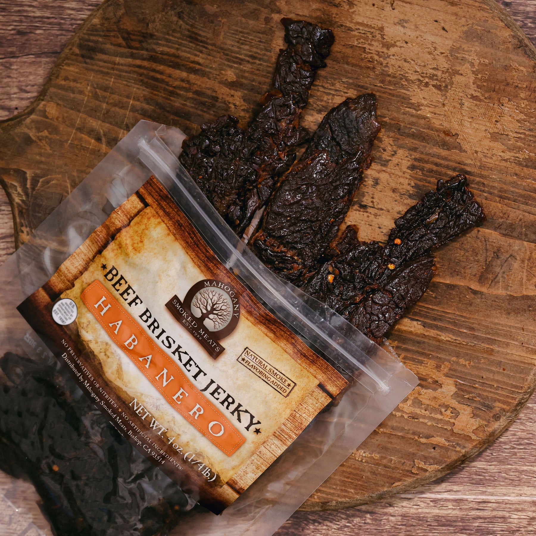 Packaged habanero beef brisket jerky on a wooden board, partially out of the bag.
