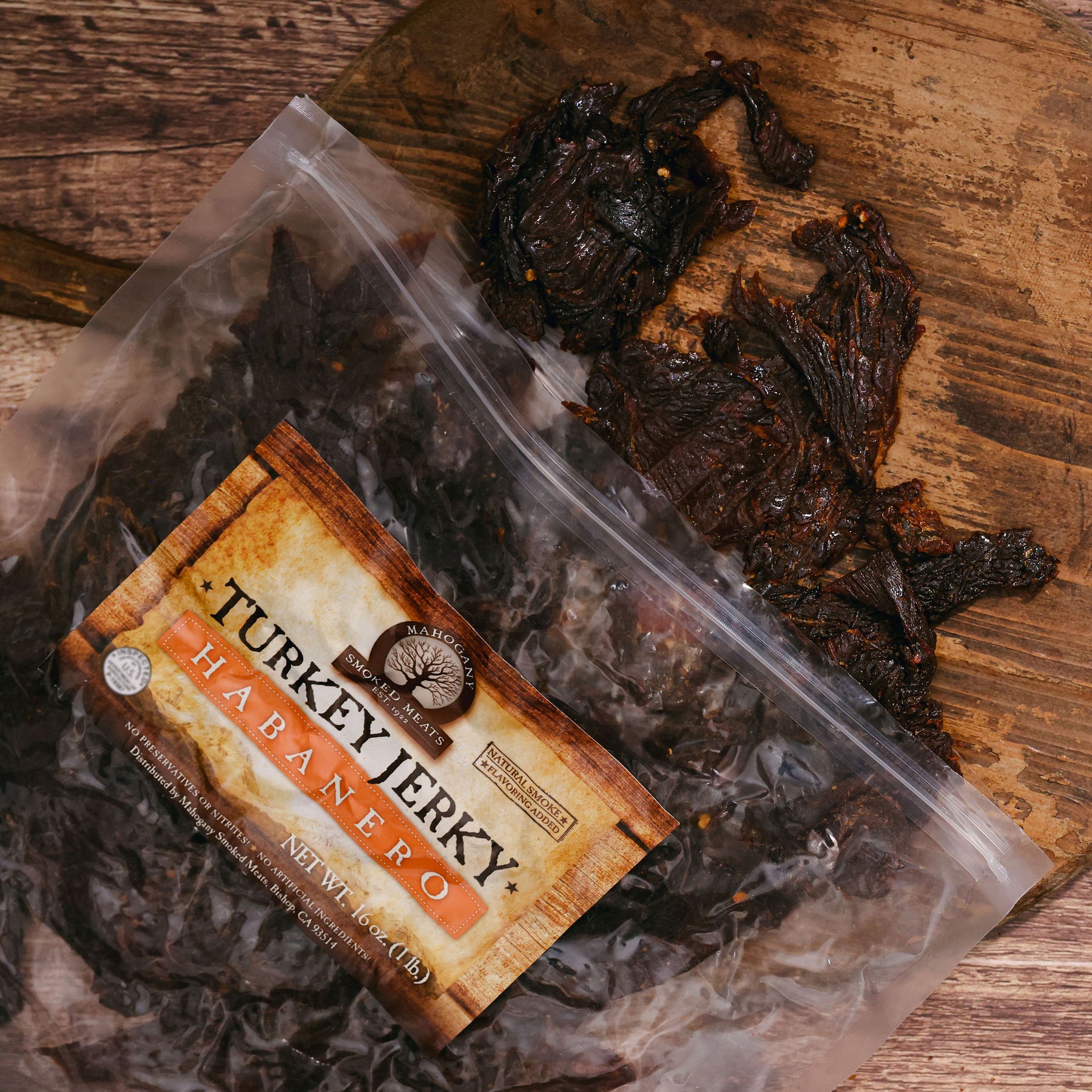 Packaged habanero turkey jerky on a wooden surface, zip-lock bag partially open with visible strips.