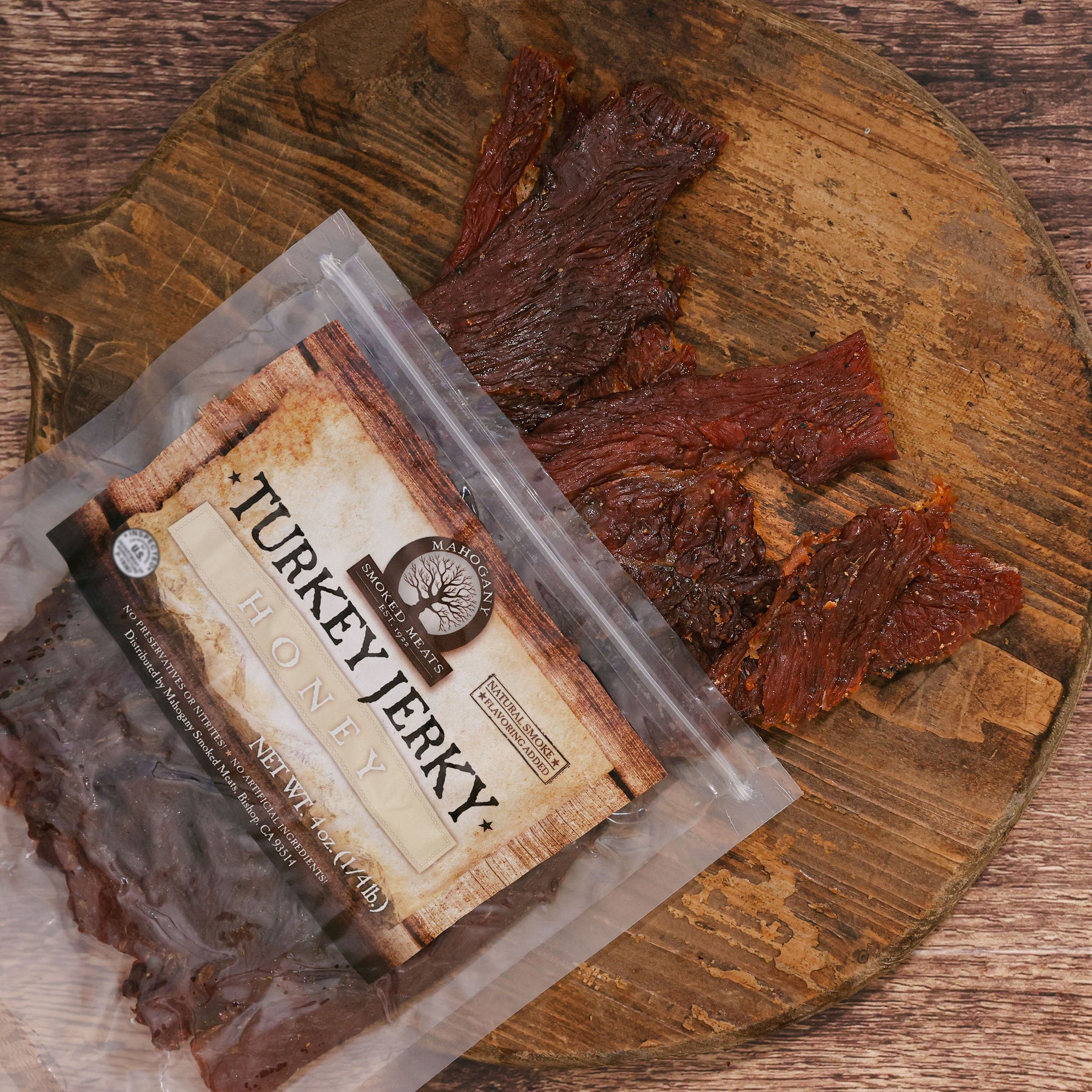 Honey turkey jerky on a rustic wooden board with open packaging