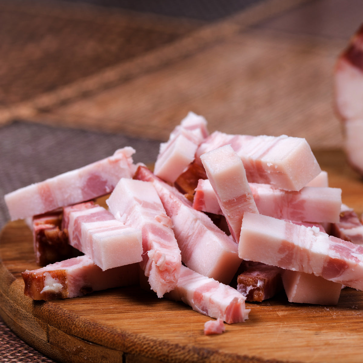 Chopped bacon ends and pieces on a wooden cutting board