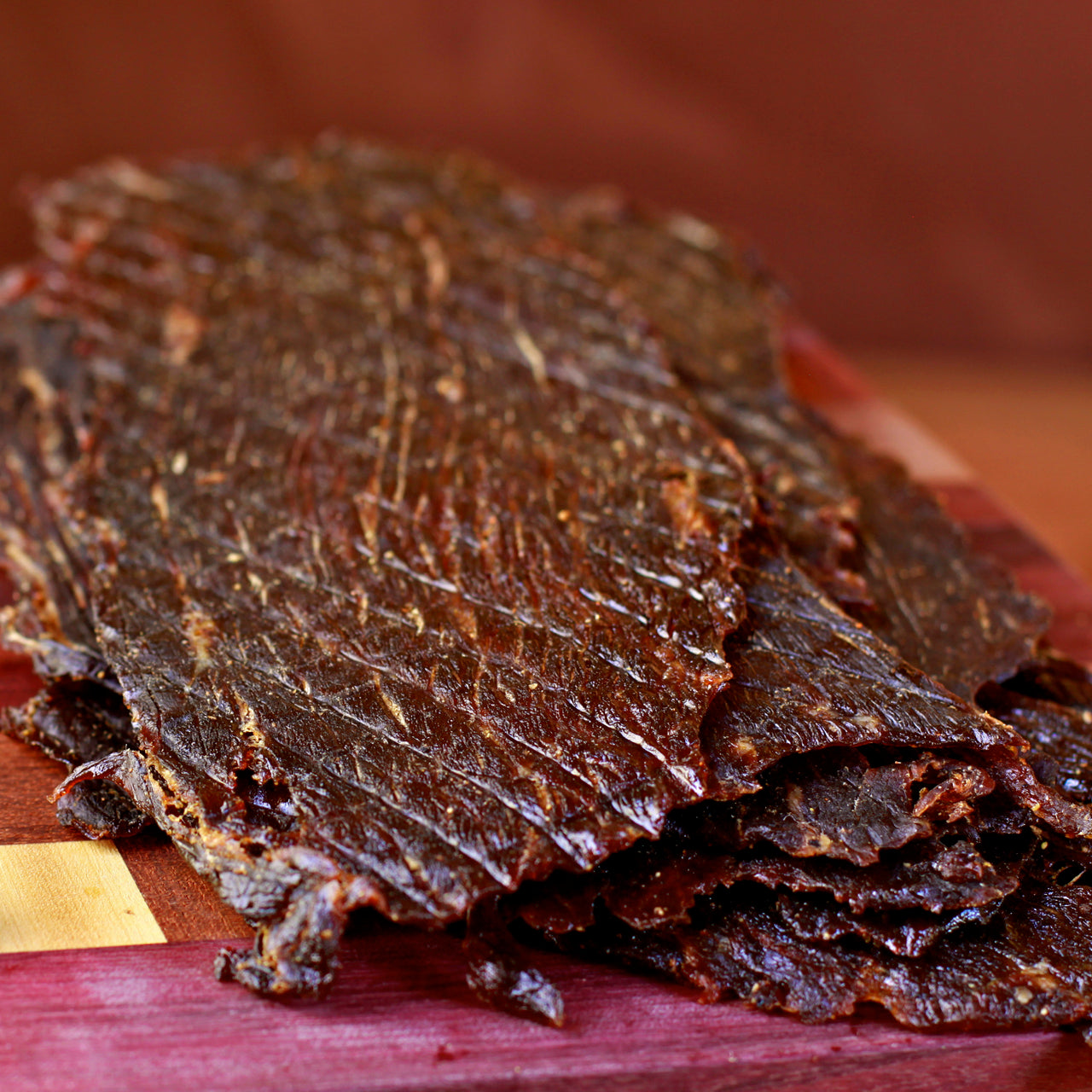 Close-up of spicy beef jerky on a wooden cutting board