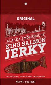 Red packaging of Alaska Smokehouse 3 oz King Salmon Jerky, featuring illustration of salmon and rustic Alaskan scene.
